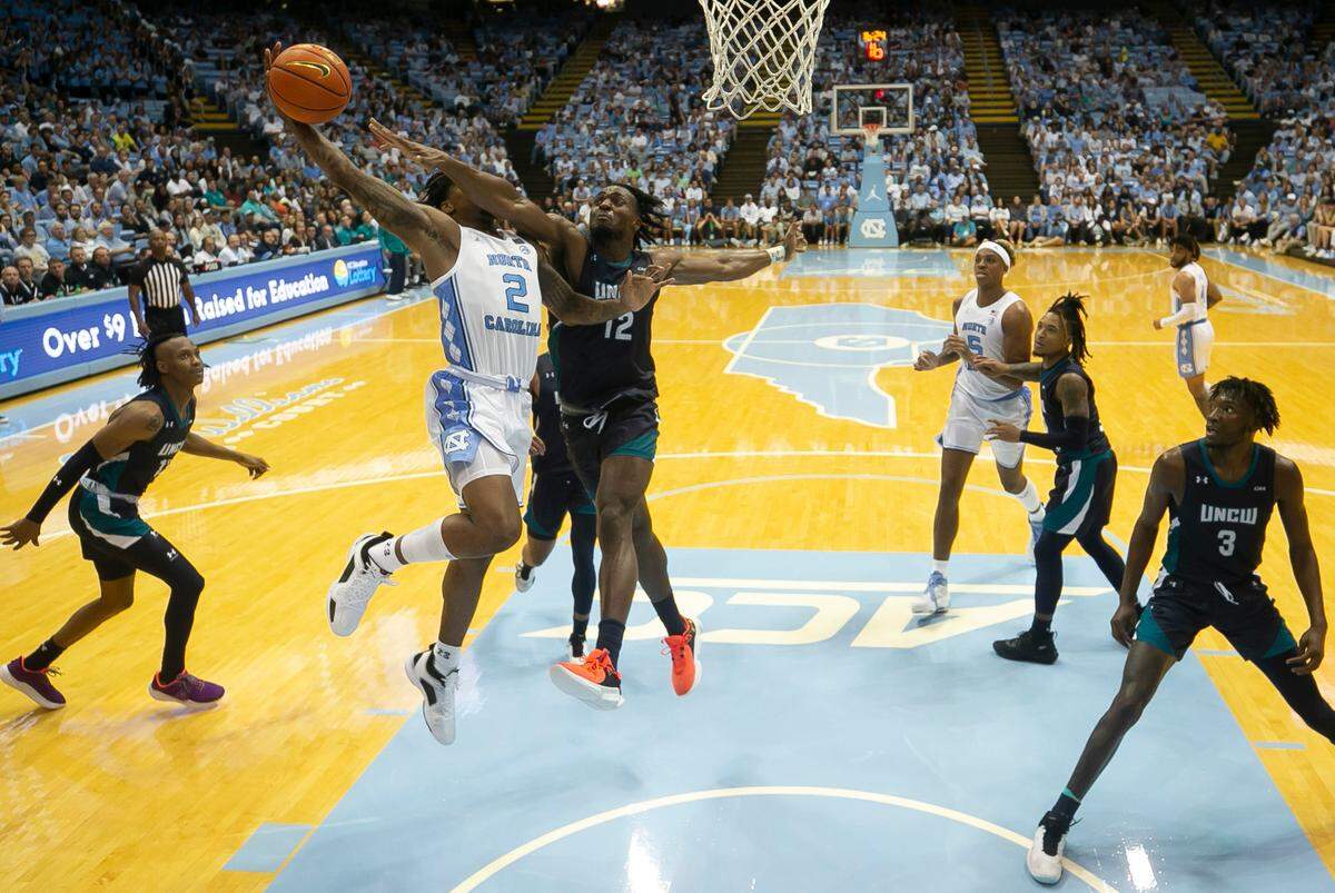 UNC Wilmington’s Victor Enoh (12) defends North Carolina’s Caleb Love (2) in the second half on Monday, November 7, 2022 at the Smith Center in Chapel Hill, N.C.