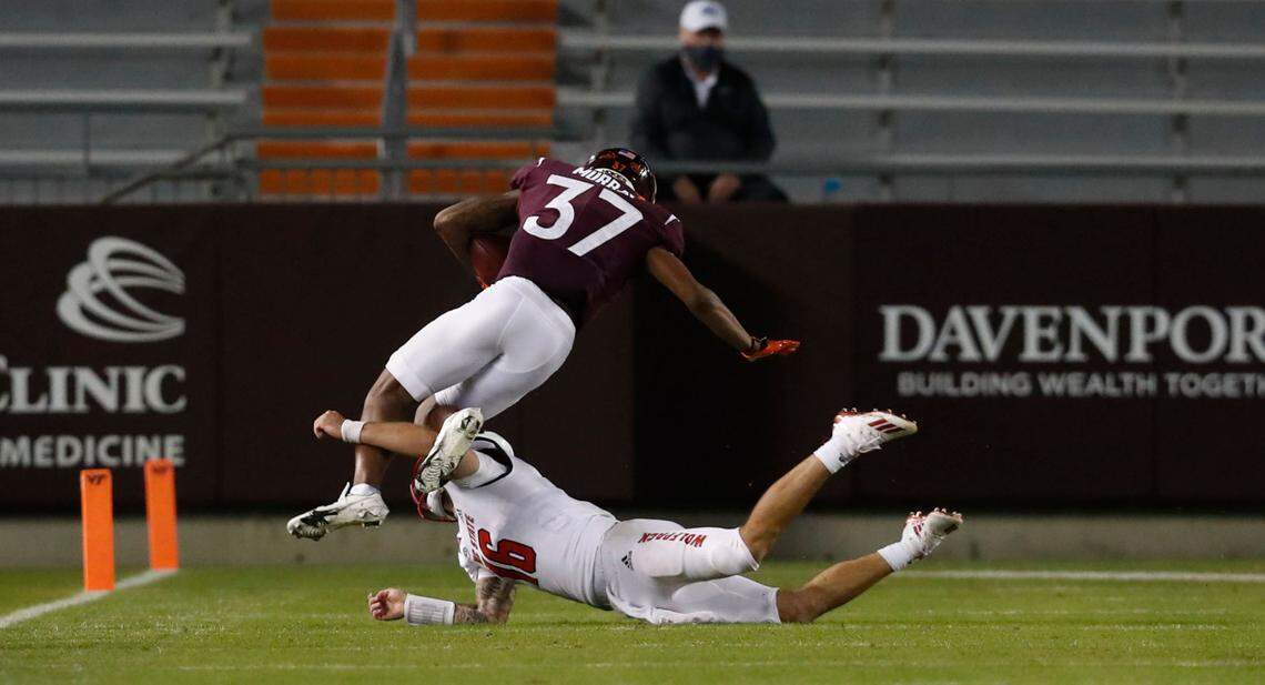 N.C. State quarterback Bailey Hockman (16) tackles Virginia Tech defensive back Brion Murray (37) after Murray intercepted Hockman’s pass during the second half of Virginia Tech’s 45-24 victory over N.C. State at Lane Stadium in Blacksburg, VA Saturday, Sept. 26, 2020.