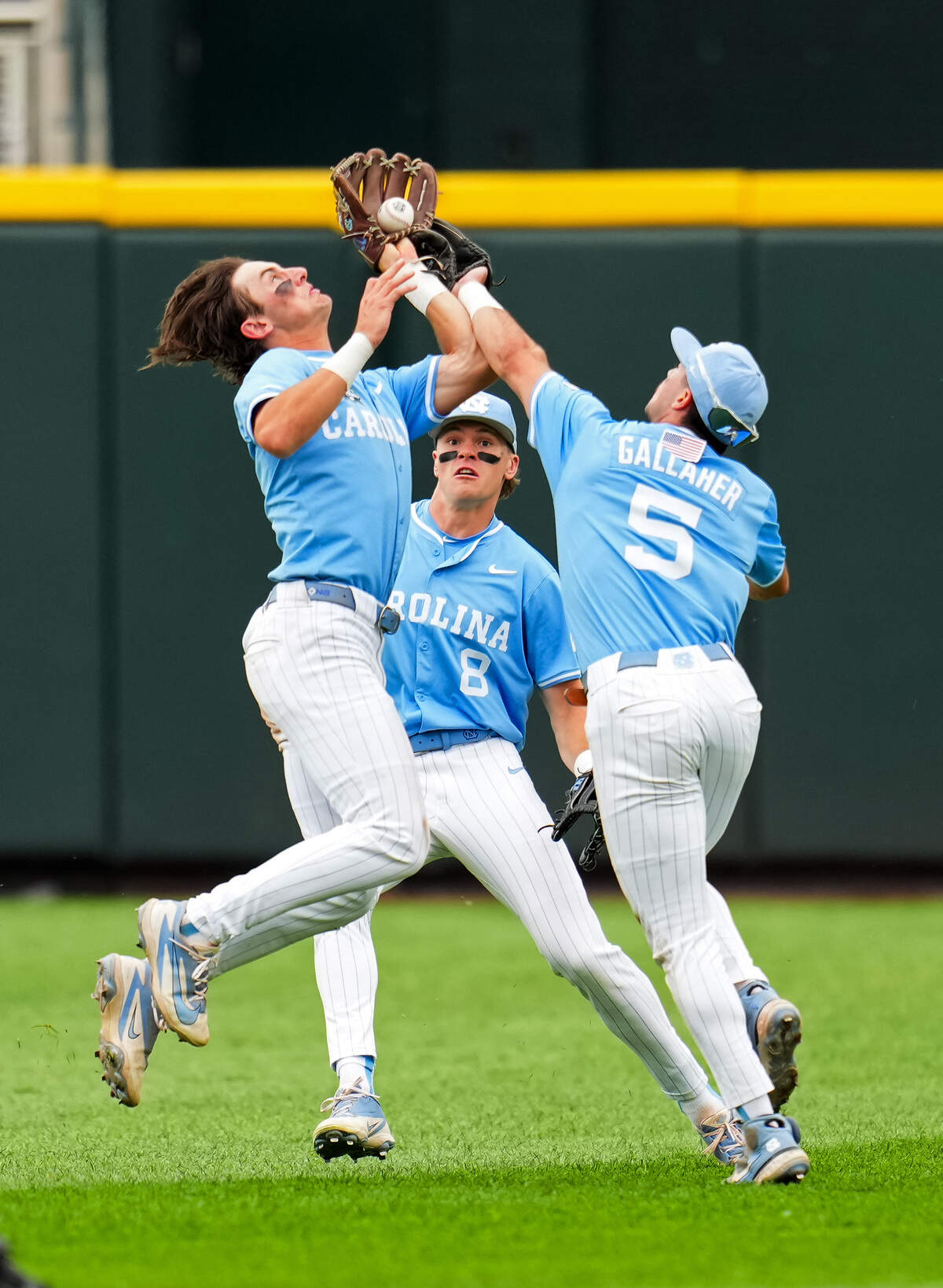 Jake Schaffner (2), Owen Hull (8) and Gavin Gallaher (5) of the North Carolina Tar Heels collide as they attempt to field a fly ball during the second inning against the Oklahoma Sooners in Game 1 of the NCAA College World Series baseball finals at Charles Schwab Field on June 20, 2026, in Omaha, Nebraska.
