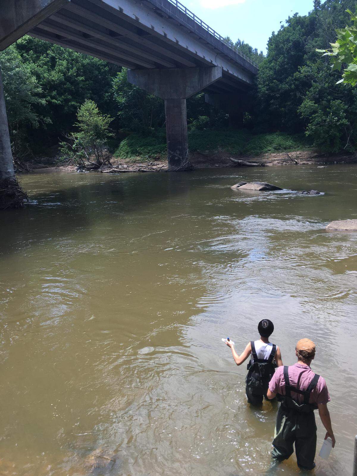 Duke researchers collecting water samples in the Haw River in July, 2019. They are collecting samples from 12 spots on the river to test for PFAS contamination.