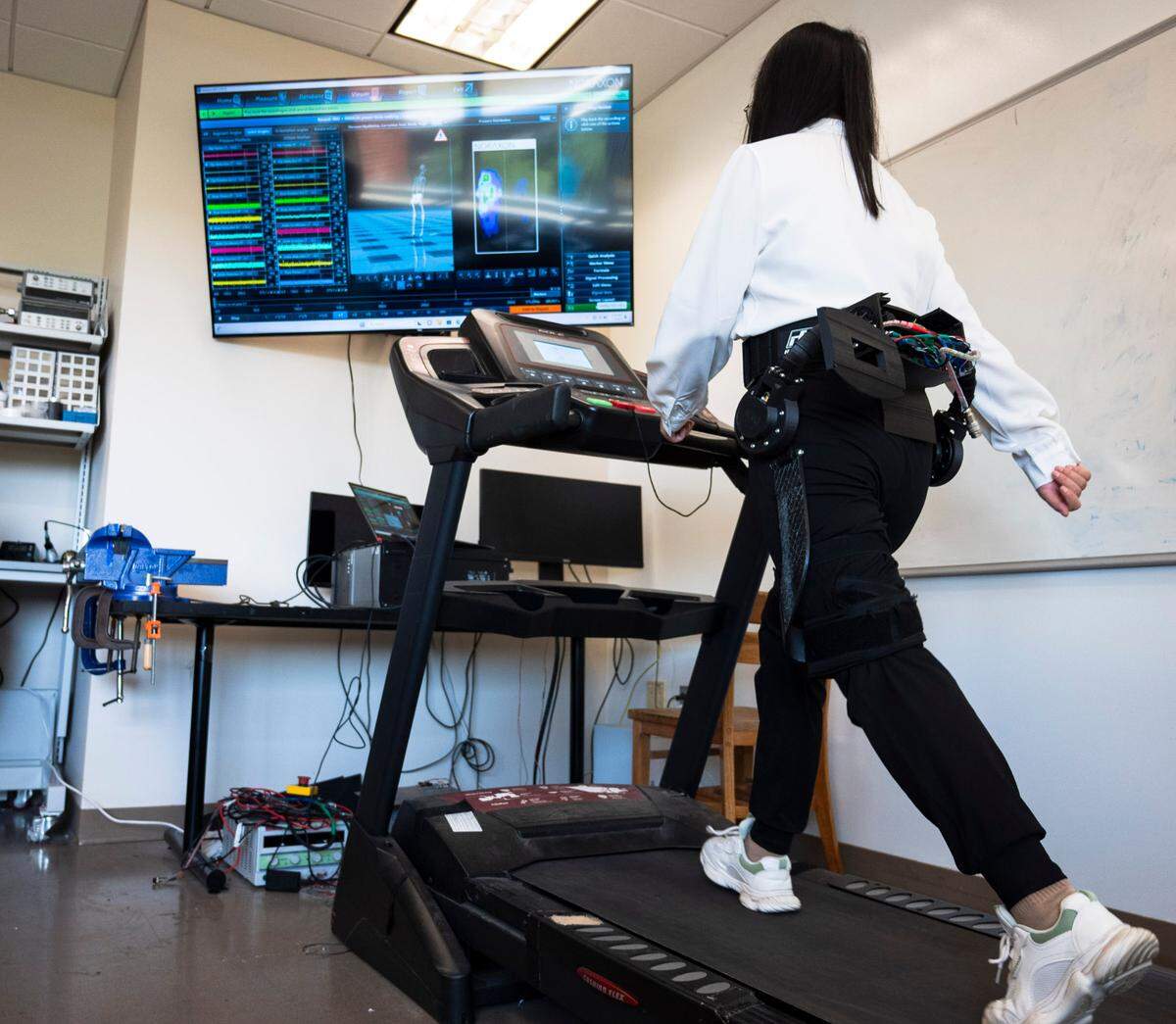 Sainan Zhang who works on control design at the lab demonstrates how the AI robotic exoskeleton can assist with walking at the Biomechatronics and Intelligent Robotics Lab at N.C. State in Raleigh on Monday, July 1, 2024.
