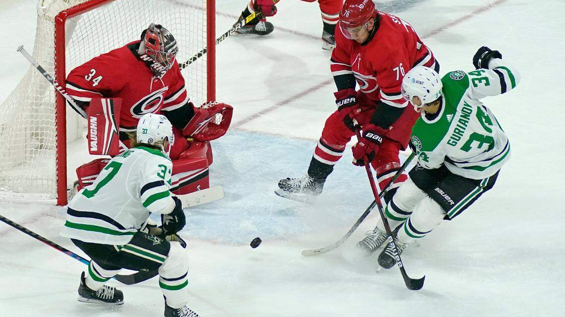 Carolina Hurricanes goaltender Petr Mrazek watches the puck while Hurricanes defenseman Brady Skjei (76) defends against Dallas Stars right wing Denis Gurianov (34) and center Justin Dowling (37) during the third period of an NHL hockey game in Raleigh, N.C., Sunday, April 4, 2021. (AP Photo/Gerry Broome)