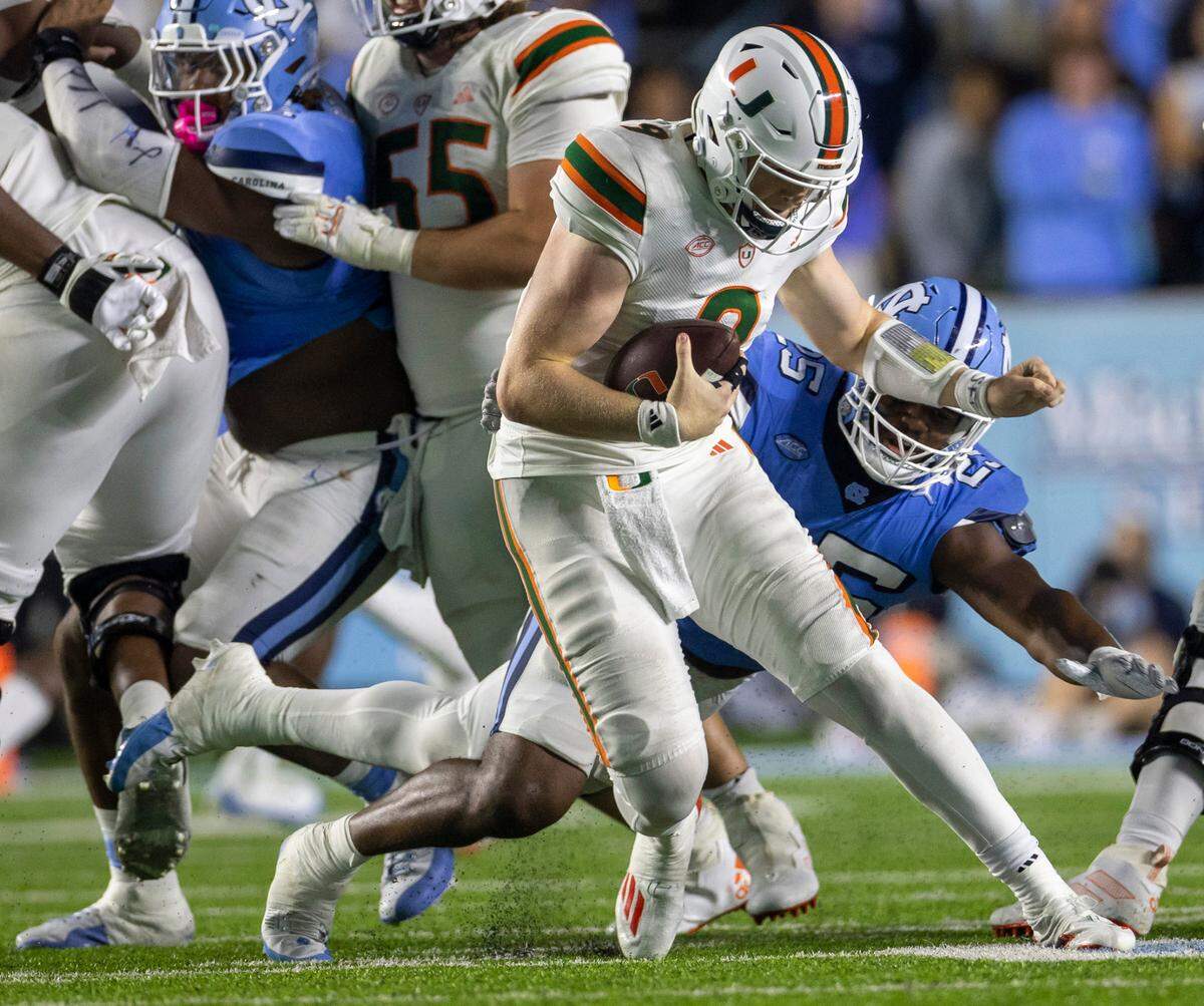 North Carolina’s Kaimon Rucker (25) slows Miami quarterback Tyler Van Dyke (9) as he is dropped for an 11-yard loss in the third quarter on Saturday, October 14, 2023 at Kenan Stadium in Chapel Hill, N.C.