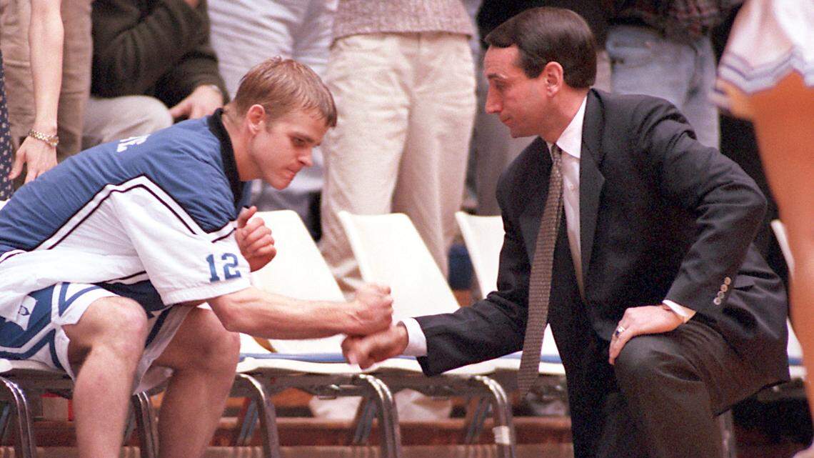 Duke’s Steve Wojciechowski(12) knocks fists with head coach Mike Krzyzewski before a game against North Carolina in 1997.