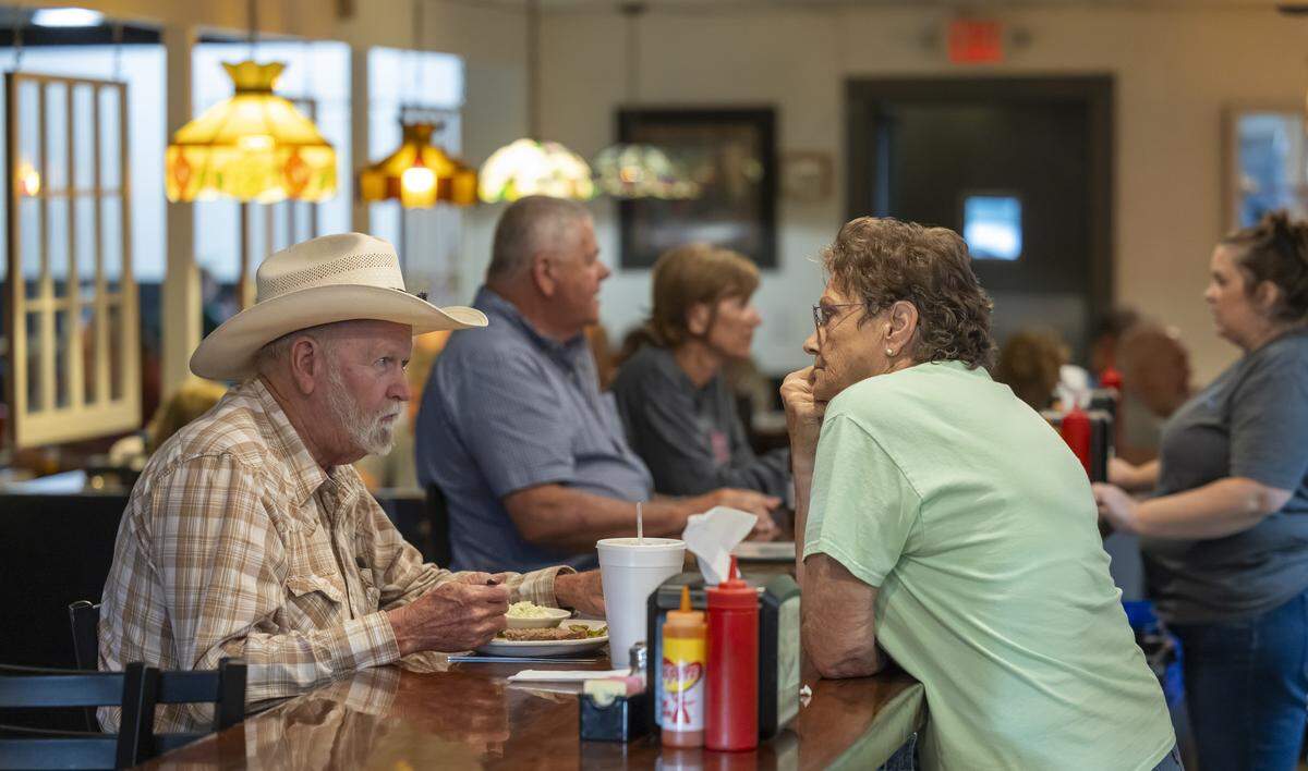 Lonnie Parcell talks with Pat Godfrey over his supper at Virlie’s Grill on Thursday July 10, 2025 in downtown Pittsboro, N.C.