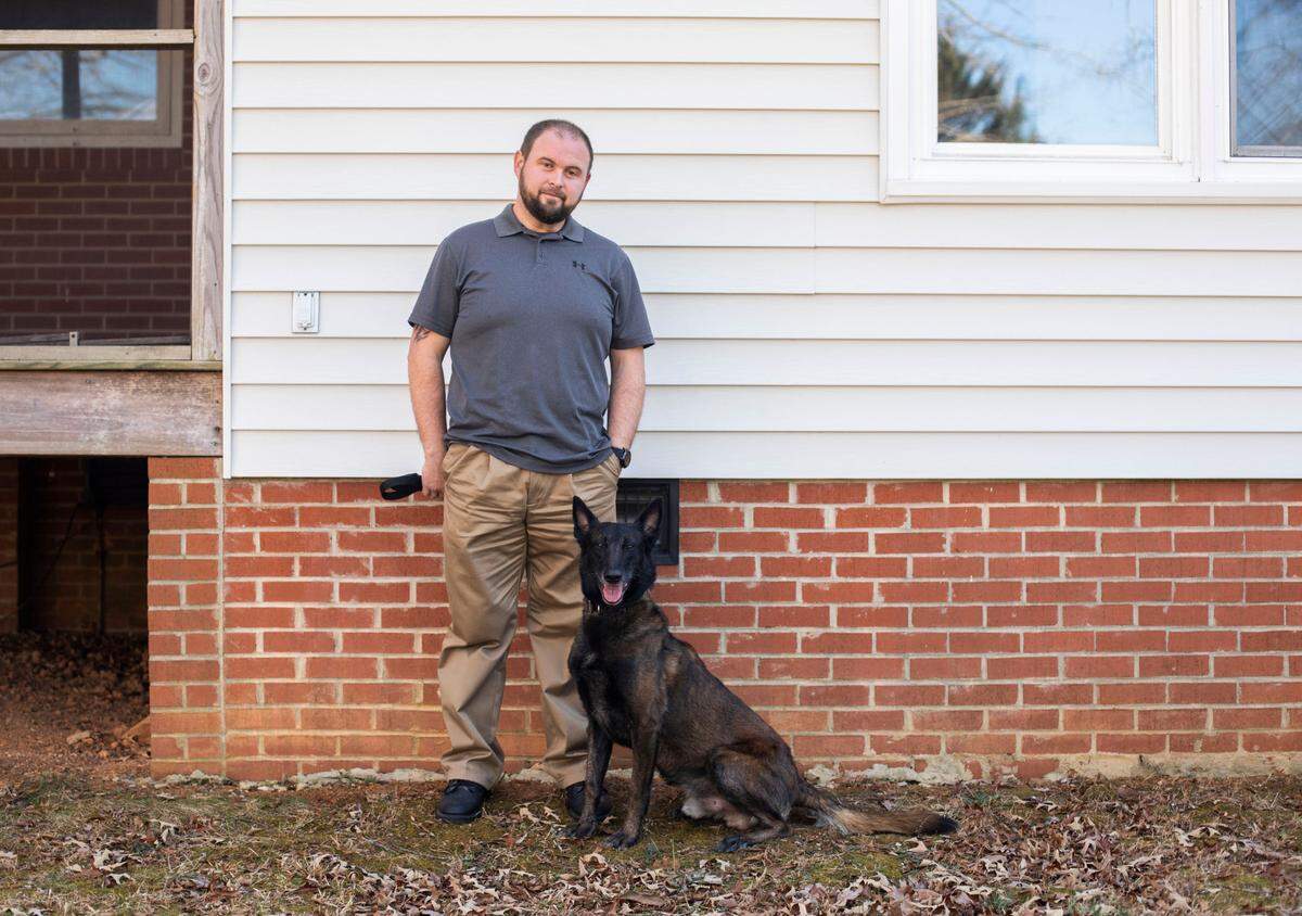 William Carson and his dog Tap, both formerly of the Durham County Sheriff’s Office, stand for a portrait in Durham, N.C. on Thursday Jan. 27, 2022.