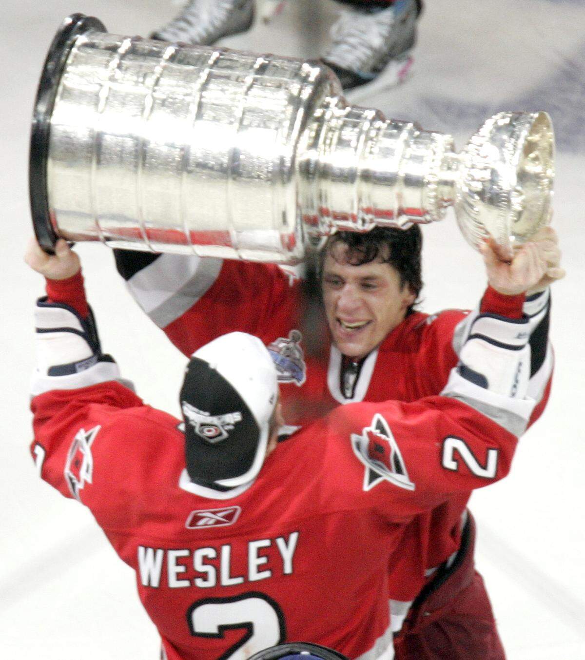 Rod Brind'Amour hands the Stanley Cup off to Glen Wesley after Game 7 of the Stanley Cup Finals at the RBC Center on Monday, June 19, 2006.