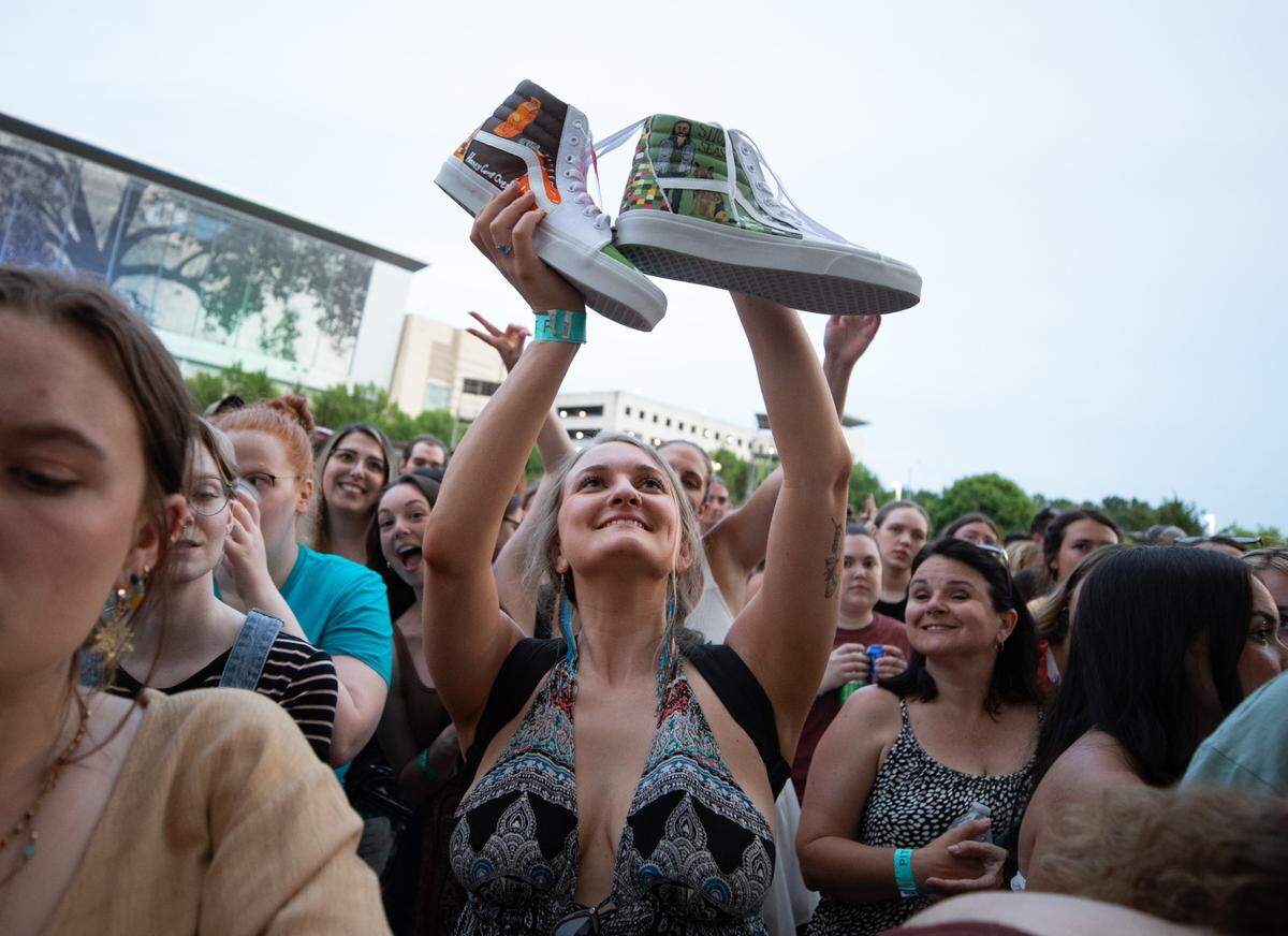 A fan holds up a pair of hand-painted Noah Kahan themed shoes ahead of Kahan’s “Stick Season Tour” performance at Red Hat Amphitheater in Raleigh, N.C. on Wednesday, June 14, 2023.