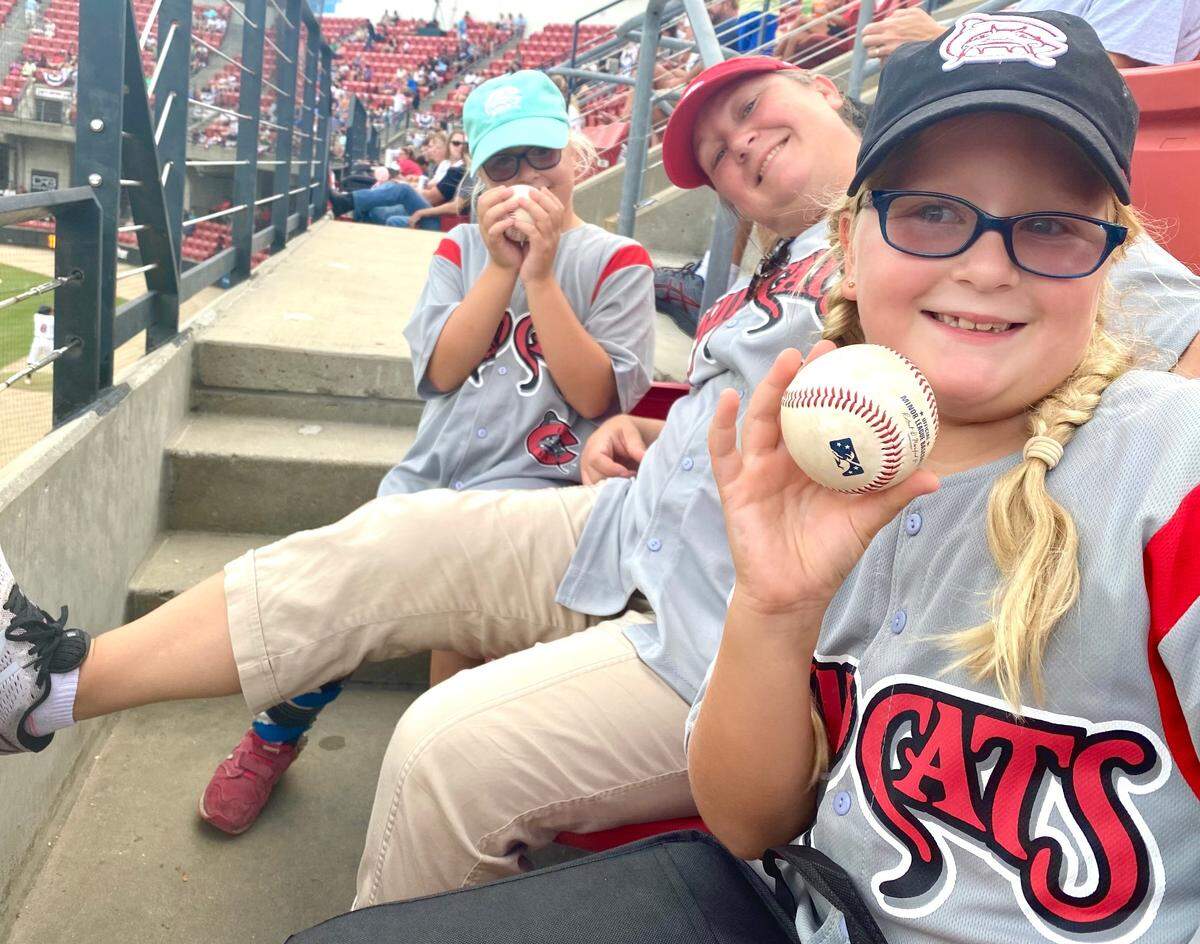 From left, Emma, Alicia and Erin Pelletier are all smiles after catching baseballs at a Carolina Mudcats game in 2022.