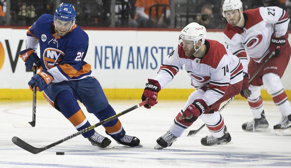 The Carolina Hurricanes’ Jaccob Slavin (74) defends New York Islanders’ Devon Toews (25) in the third period during Game 1 of the second round Stanley Cup series on Friday, April 26, 2019 at Barclays Center in Brooklyn, N.Y.