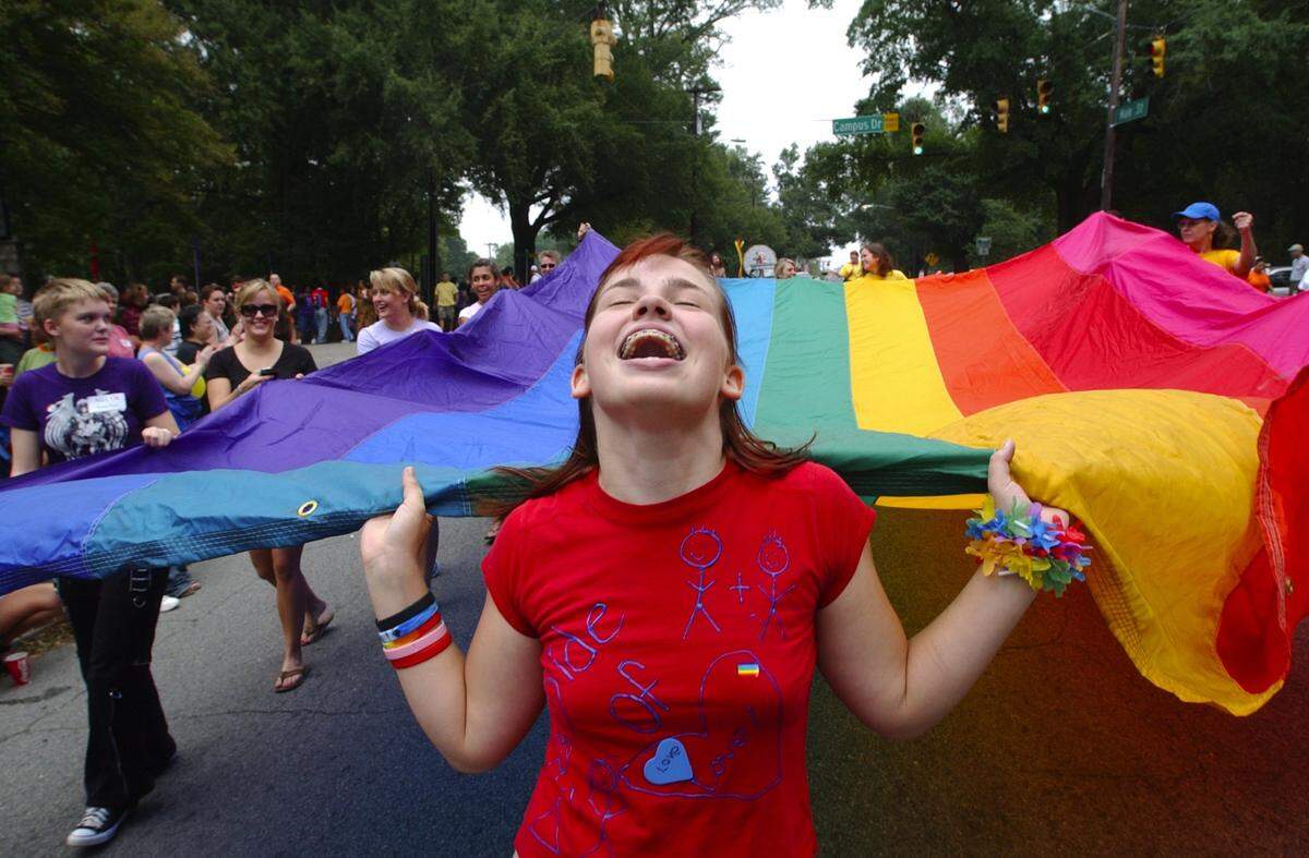 Ariel Frawley of Wake Forest helps carry the large diversity flag at the 2005 NC Gay Pride Parade in Durham, NC. The first Pride parade in Durham was June 27, 1981, and it was called Our Day Out.
