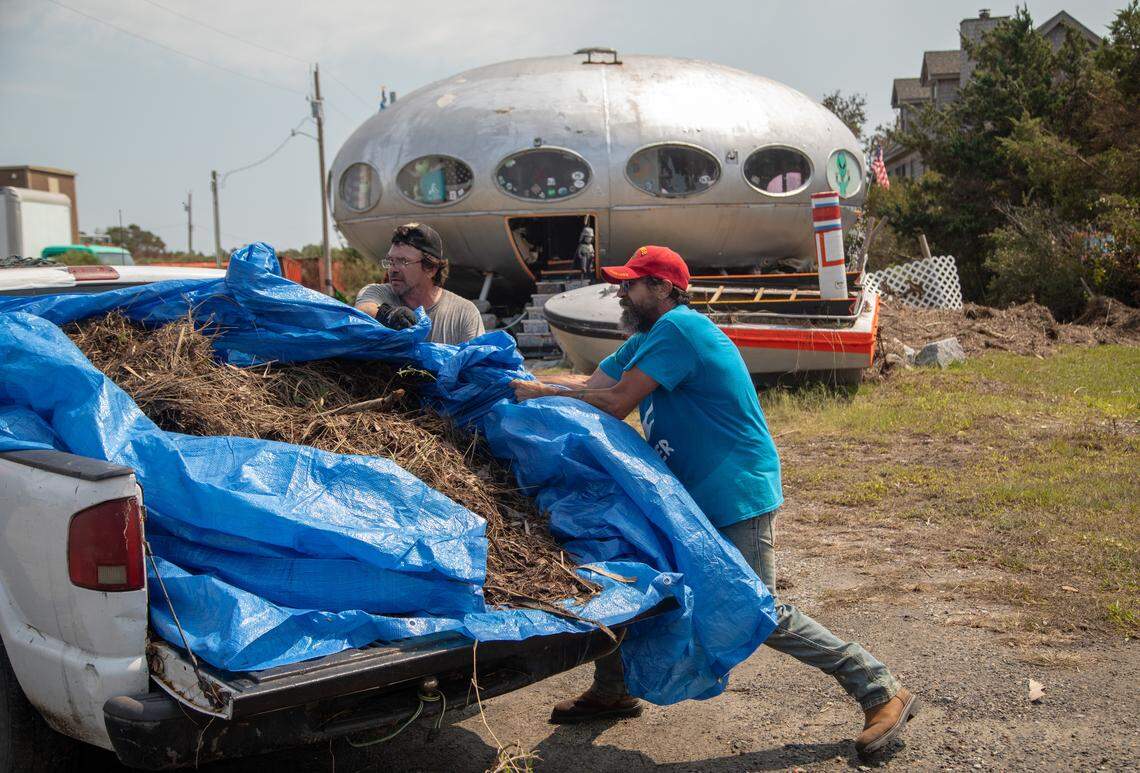 LeRoy Reynolds, right, and his brother Denny Reynolds unload a truck filled with debris onto the roadside in Frisco Sunday, Sept. 8, 2019 in the aftermath of Hurricane Dorian.