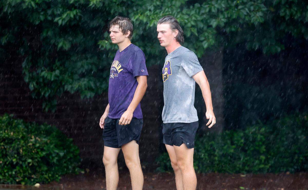 Fans stand out in the rain during a weather delay in the first inning during ECUs game against Texas in the Greenville Super Regional at Clark-LeClair Stadium Sunday, June 12, 2022.