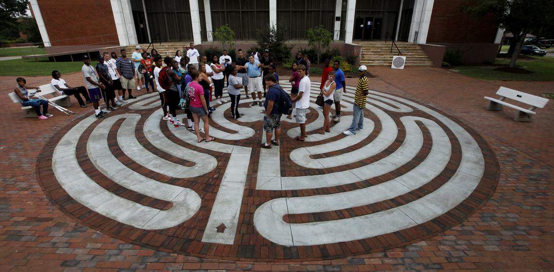 Louisburg College art professor Will Hinton, center, leads a group of incoming students through an orientation tour of the “labyrinth”in 2011.