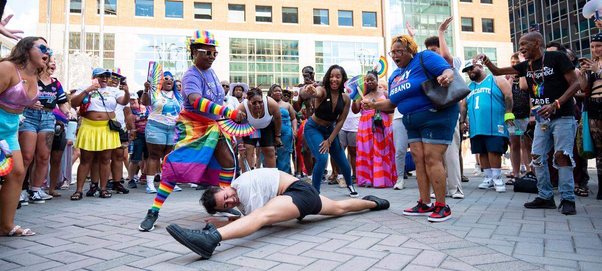 People cheer and fan Nick as he does a split in the middle of the dance circle near the main stage at Raleigh Pride on Saturday, June 22, 2024.