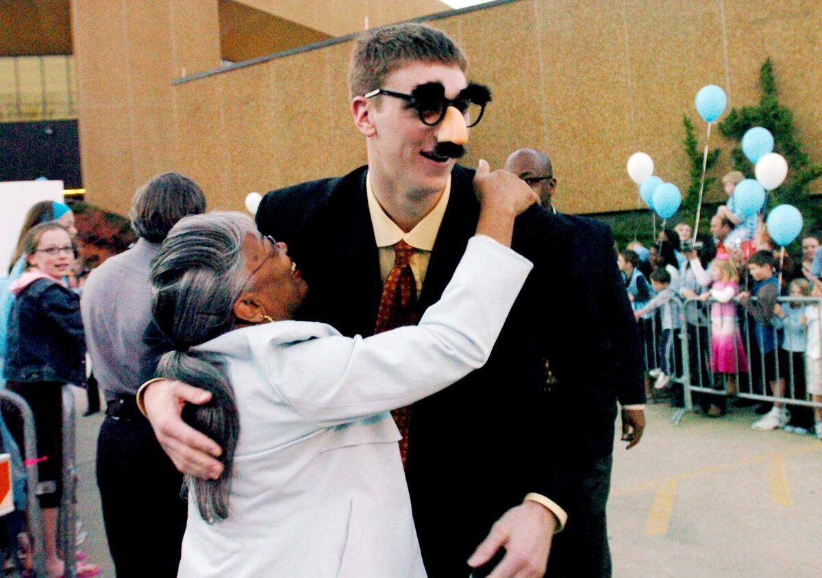 UNC's Tyler Hansbrough wearing a Groucho Marx mask  is hugging Lillian Lee,Wednesday,March, 07, 2007, outside the Dean Smith Center as the team departed for the ACC Tournament.
