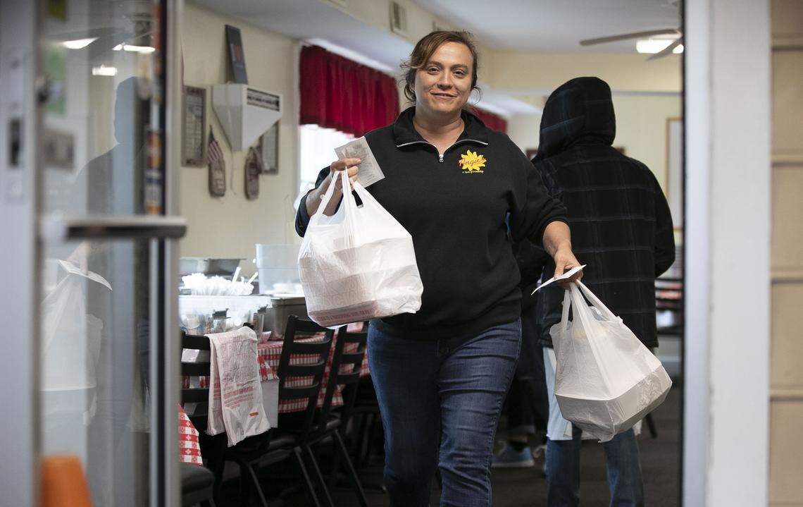 Angie Mikus delivers a take-out order to a customer on April 23, 2020 in Garner. N.C. The restaurant transitioned to carhop service after the dining room was closed in March due to the spread of the COVID-19 virus.