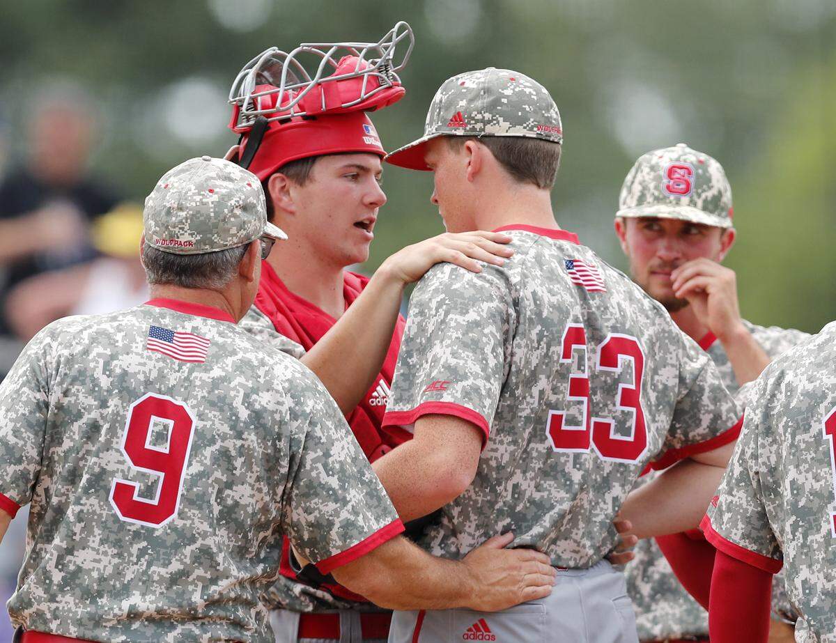 N.C. State’s Patrick Bailey (5) talks with Michael Bienlien (33) during N.C. State’s game against East Carolina University in the Greenville Regional at Clark-LeClair Stadium in Greenville, N.C., Sunday, June 2, 2019. N.C. State head coach Elliott Avent is to the left.