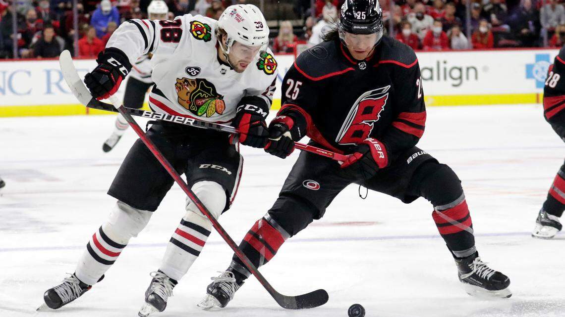Former Chicago Blackhawks left wing Brandon Hagel (38), traded this week to Tampa Bay, battles Carolina Hurricanes defenseman Ethan Bear (25) in NHL hockey game Friday, Oct. 29, 2021, in Raleigh, N.C. (AP Photo/Chris Seward)