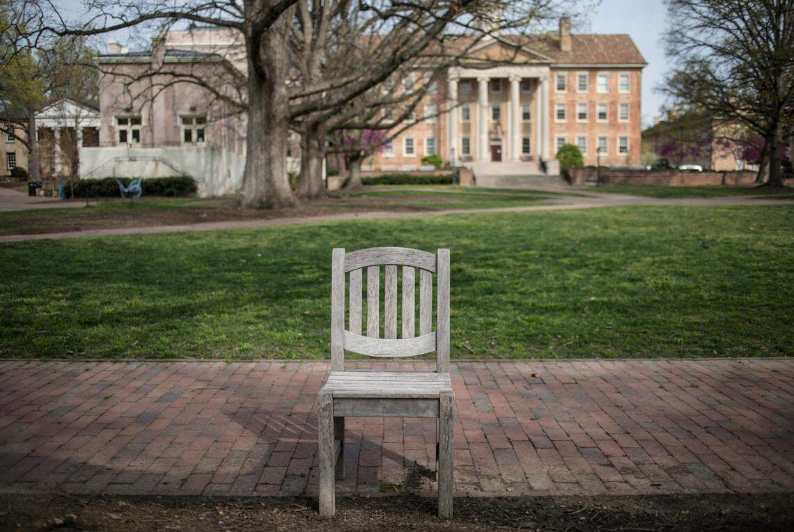 An empty chairs sits in an empty Polk Place on UNC-Chapel Hill’s campus on Friday, March 27, 2020. University campuses across North Carolina closed earlier this month to prevent the spread of coronavirus, leaving them looking like ghost towns.