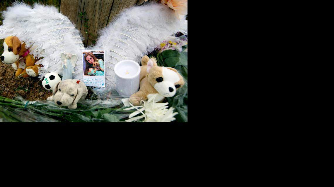 Rachel Porter, not seen, leaves behind angel wings that she made at a makeshift memorial for her friend. Laura Yost, the Panther Creek High School student involved in a car accident on her way to school last week, died on Sept. 23, 2014. After school, teens paid their respects at the accident scene at the corner of Highway 55 and McCrimmon Parkway.
