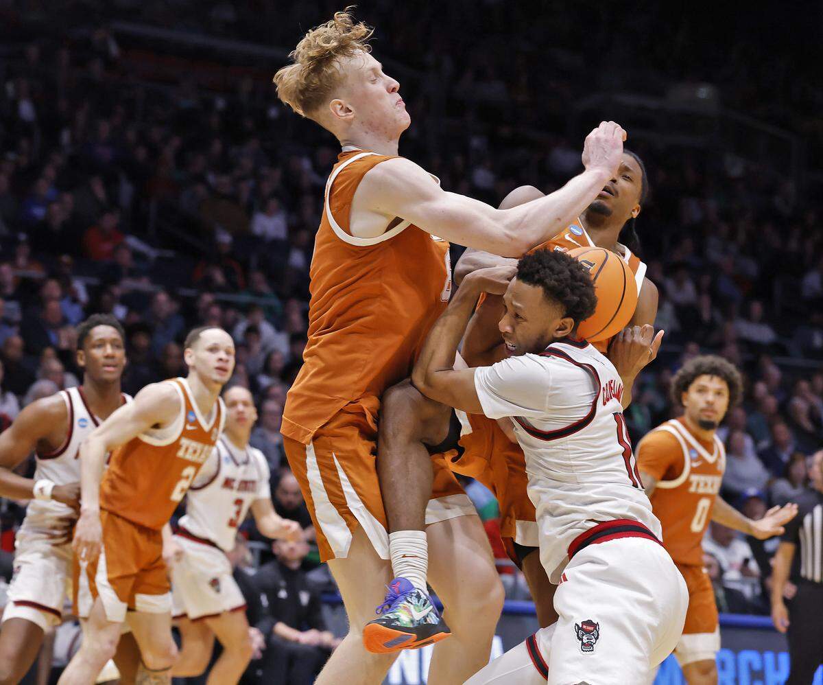 N.C. State’s Quadir Copeland is met by pressure from Texas’ Matas Vokietaitis and Tramon Mark during the second half of the Wolfpack’s 68-66 loss in the NCAA First Four on Tuesday, March 17, 2026, at the University of Dayton Arena in Dayton, Ohio. 