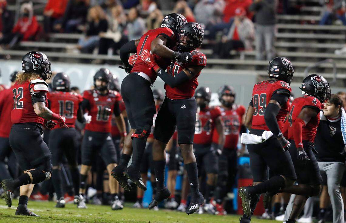 N.C. State linebacker Isaiah Moore (1) celebrates with Vi Jones (31) after forcing Florida State to turnover the ball on downs during the first half of N.C. State’s game against Florida State at Carter-Finley Stadium in Raleigh, N.C., Saturday, Nov. 14, 2020.