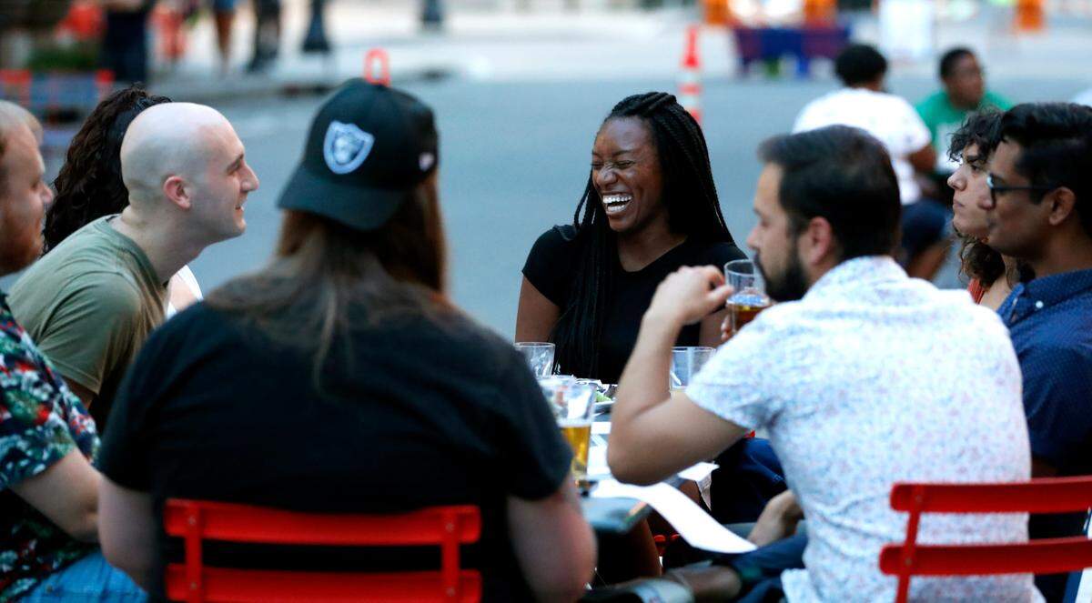 Sydney Harris of Raleigh, center, laughs with friends at The Big Easy NC on Fayetteville Street in downtown Raleigh, N.C., during Dine Out Downtown Saturday, May 22, 2021.