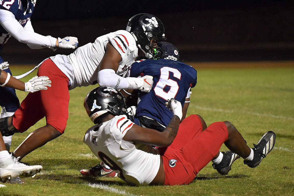 Rolesville defensive lineman Zavion Griffin-Haynes (9) grapples Apex Friendship running back Michael Mallard (6) during the first half. The Apex Friendship Patriots and the Rolesville Rams met in  the second round of the  NCHSAA 8A Playoff game in Apex, N.C. on November 14, 2025. Rolesville wins 14-7 in overtime.