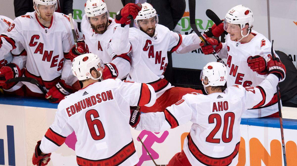 Carolina Hurricanes center Sebastian Aho (20) is congratulated by teammates Joel Edmundson (6) , Warren Foegele (13), Jordan Martinook (48), Vincent Trocheck (16) and Brock McGinn (23) after scoring against the New York Rangers during the third period of an NHL hockey playoff game Tuesday, Aug. 4, 2020, in Toronto. (Frank Gunn/The Canadian Press via AP)