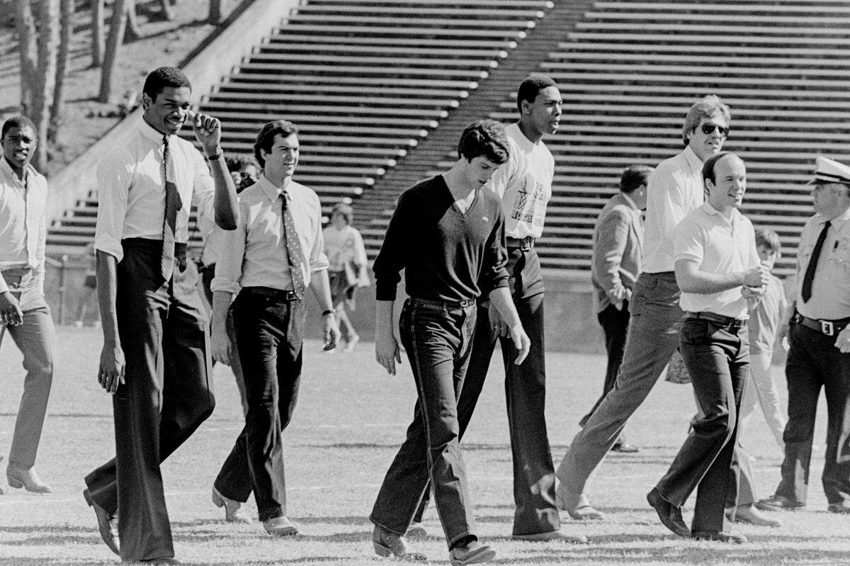 UNC basketball players and managers walk across the field at Kenan Stadium for a hastily-organized welcome home ceremony after defeating Georgetown to win the National Championship.
