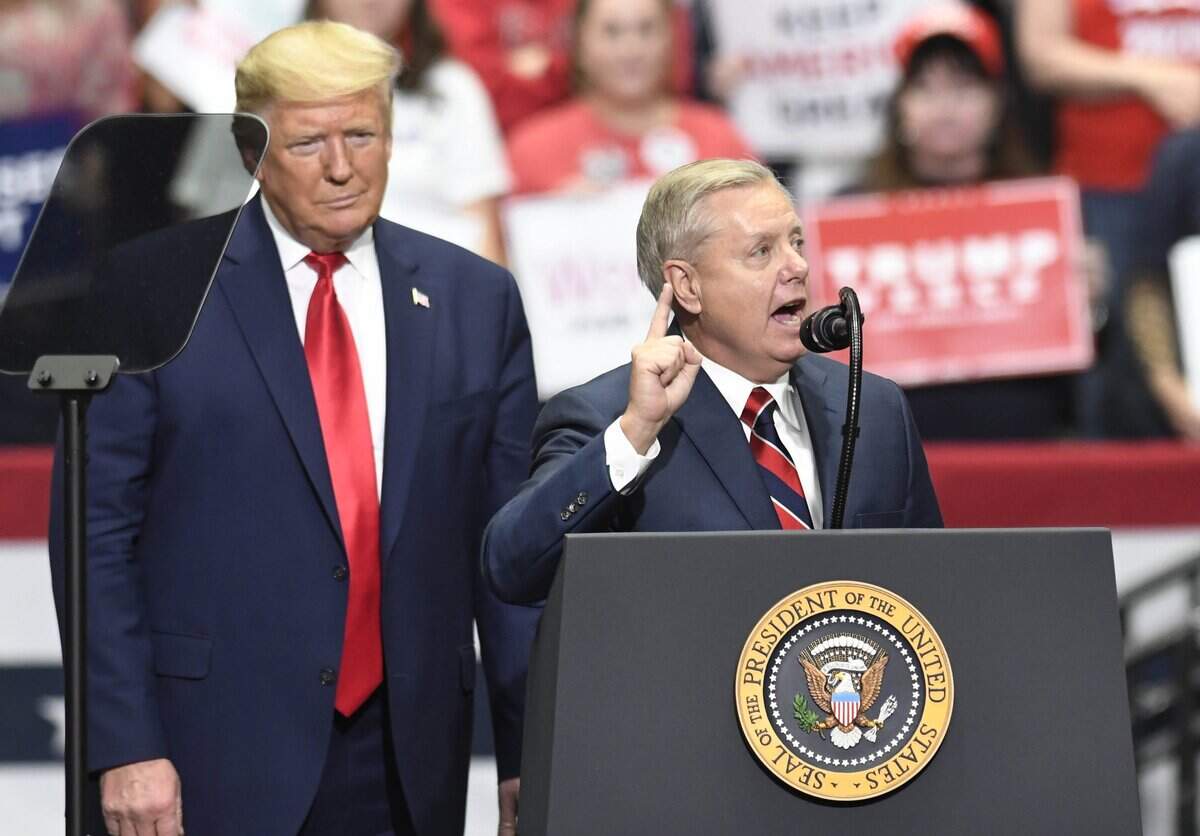 President Donald J. Trump listens as U.S. Senator Lindsey Graham of South Carolina addresses supporters during a rally at Bojangles Arena in Charlotte, NC on Monday, March 2, 2020, on the eve of the Super Tuesday primaries.
