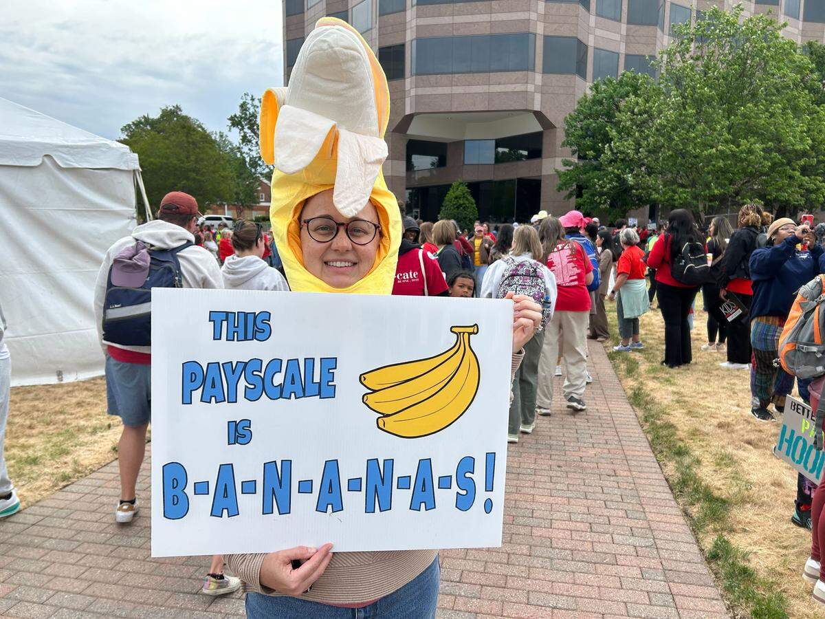 Annie Toth, a science teacher at Myers Park High School in Charlotte displays her sign before the teachers march in Raleigh.