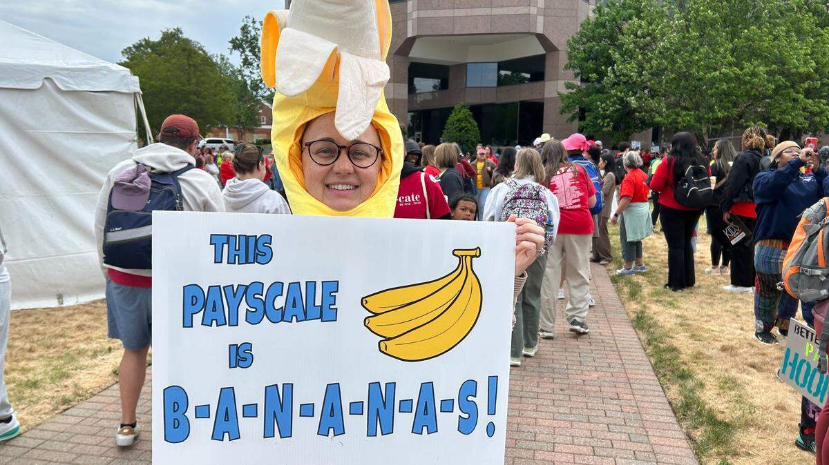 Annie Toth, a science teacher at Myers Park High School in Charlotte displays her sign before the teachers march in Raleigh.