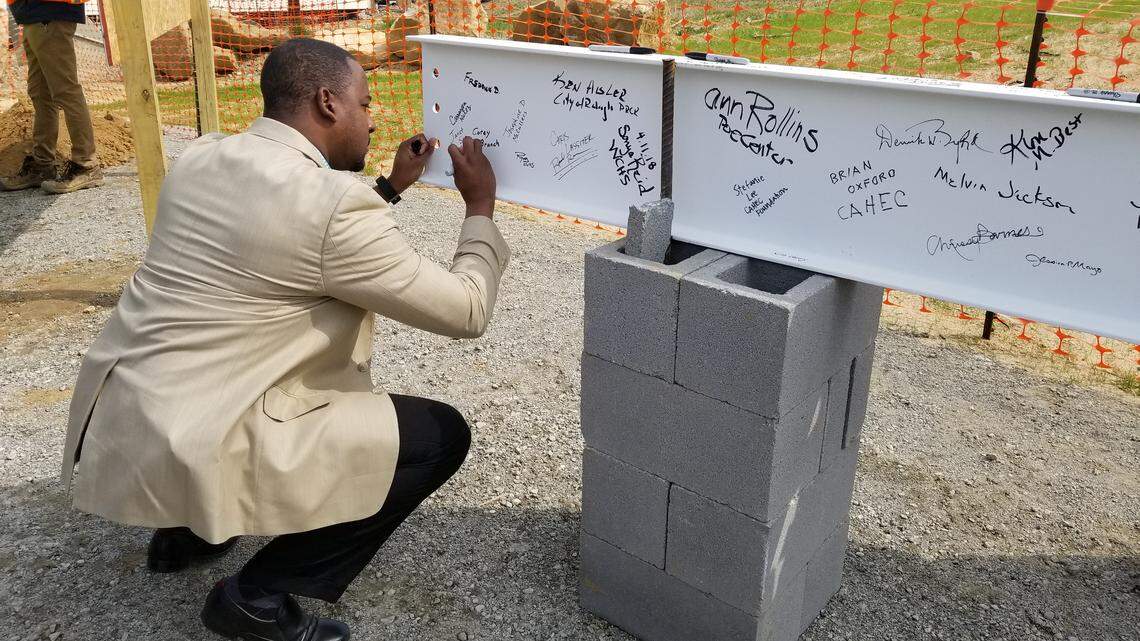 Raleigh Council member Corey Branch, who represents Southeast Raleigh, signs a beam that will be placed in the Southeast YMCA and Southeast Raleigh Elementary School. A ground-breaking for the site was held  April 11, 2018.