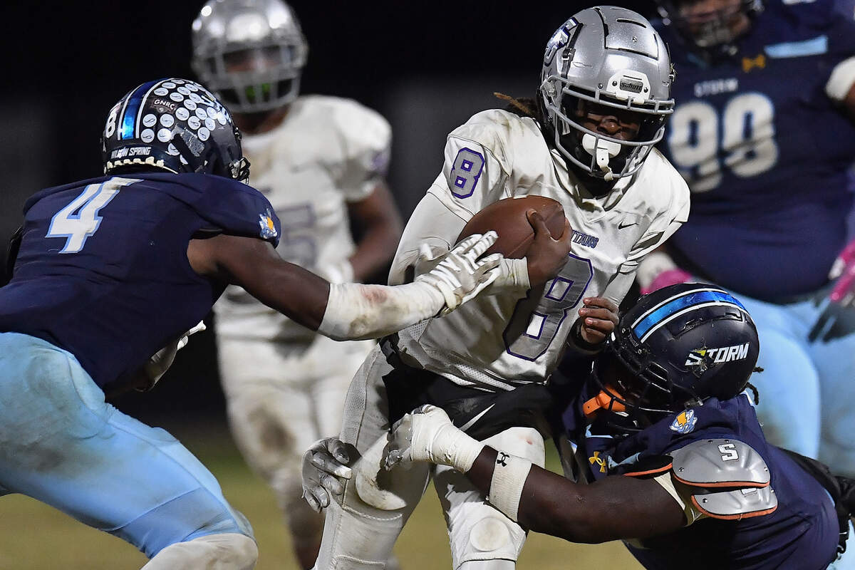 Willow Spring’s Jordan Ledgester (4) and Dylen Cooper (90) tackle South Garner quarterback Chase Hardy (8) late in the fourth quarter. The Willow Spring Storm and the South Garner Titans met in a football game in Fuquay-Varina. N.C. on October 18, 2024.