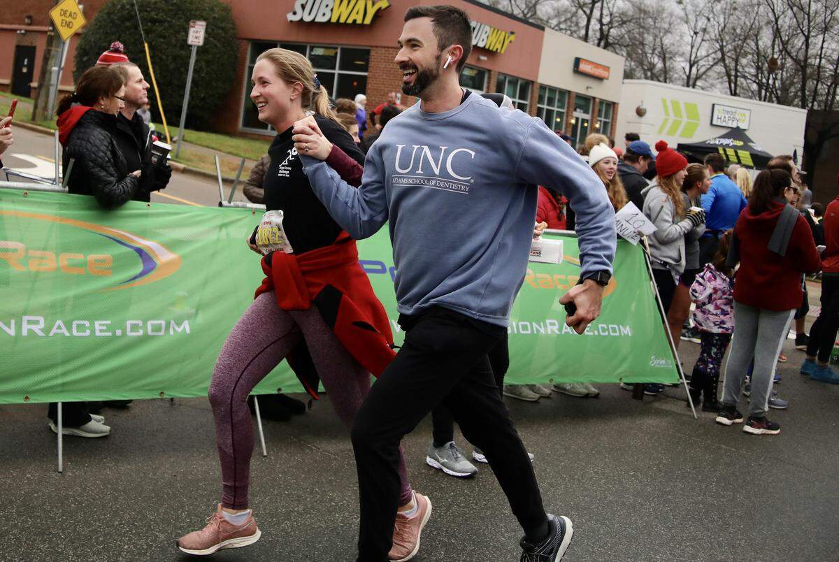 Members of the race hold hands and encourage each other to finish the Krispy Kreme Challenge race in Raleigh, N.C. on February 1, 2020.