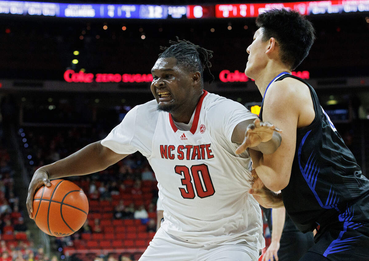 N.C. State’s DJ Burns Jr. posts up against Saint Louis’ Bruce Zhang during the first half of the Wolfpack’s game on Wednesday, Dec. 20, 2023, at PNC Arena in Raleigh, N.C.