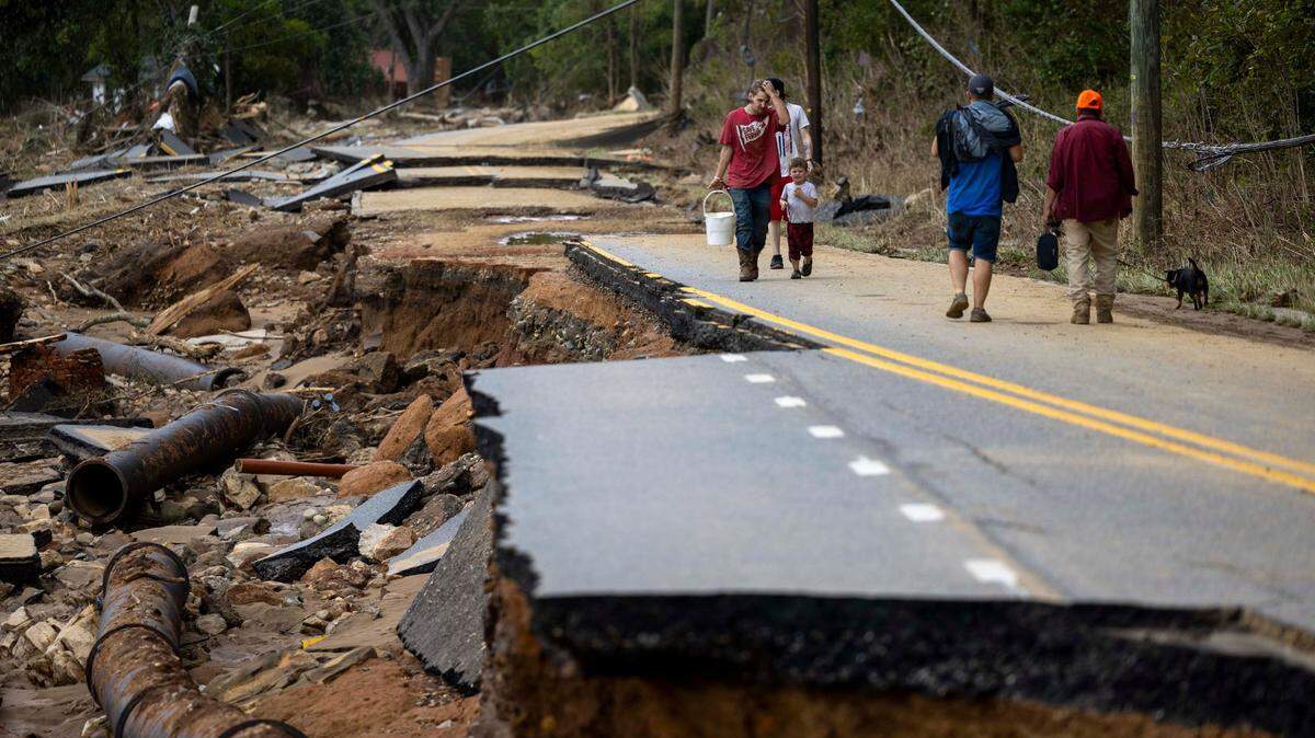 Swannanoa residents walk through devastating flood damage from the Swannanoa River in 2024. A Florida doctor has pleaded guilty to taking supplies donated for the victims and selling them at pawn shops, the Buncombe County district Attoirney’s Office says.
