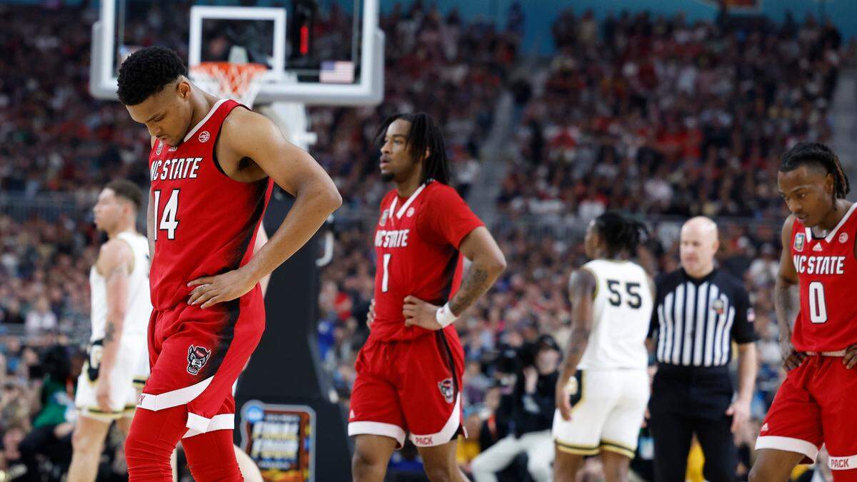 NC State’s and Casey Morsell (14), Jayden Taylor (1) and DJ Horne (0) walk to the bench during a second half timeout as they face Purdue in the Final Four, Saturday night, April 6, 2024.