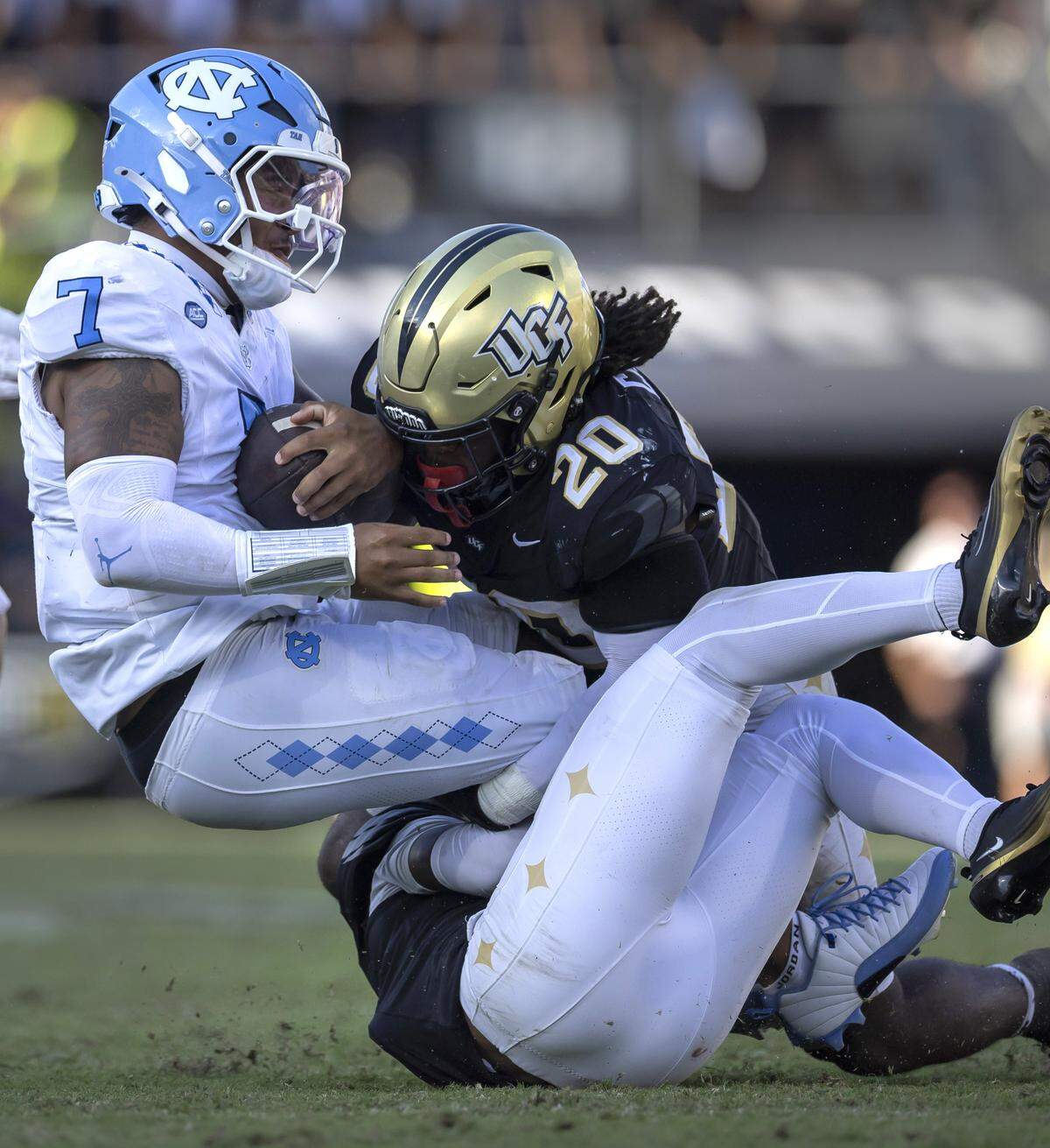 North Carolina quarterback Gio Lopez (7) stopped after a three-yard gain by UCF safety Phillip Dunnam (2)  and linebacker Lewis Carter (20) in the third quarter on Saturday, September 20, 2025 in Orlando, Fla.
