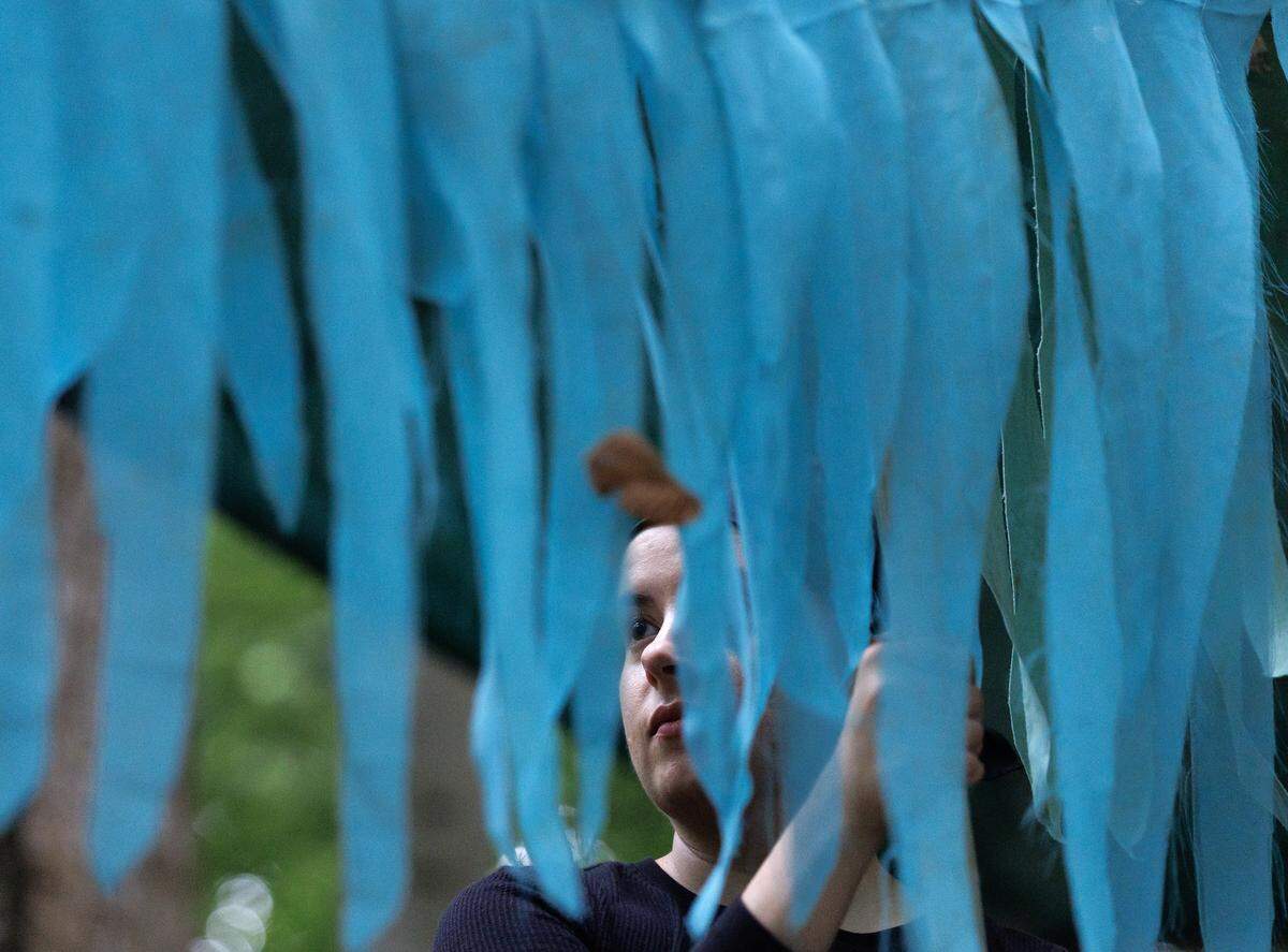 Emma Caterinicchio, a volunteer puppeteer with Paperhand Puppet Intervention, helps to hold a river puppet aloft during a rehearsal on Tuesday, Aug. 12, 2025, at the Forest Theatre in Chapel Hill, N.C. 