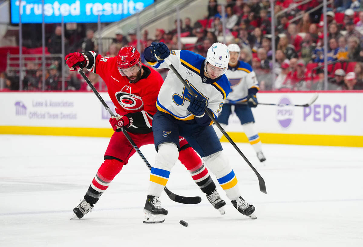Nov 17, 2024; Raleigh, North Carolina, USA; St. Louis Blues center Alexandre Texier (9) battles for the puck against Carolina Hurricanes left wing Jordan Martinook (48) during the first period at Lenovo Center. Mandatory Credit: James Guillory-Imagn Images
