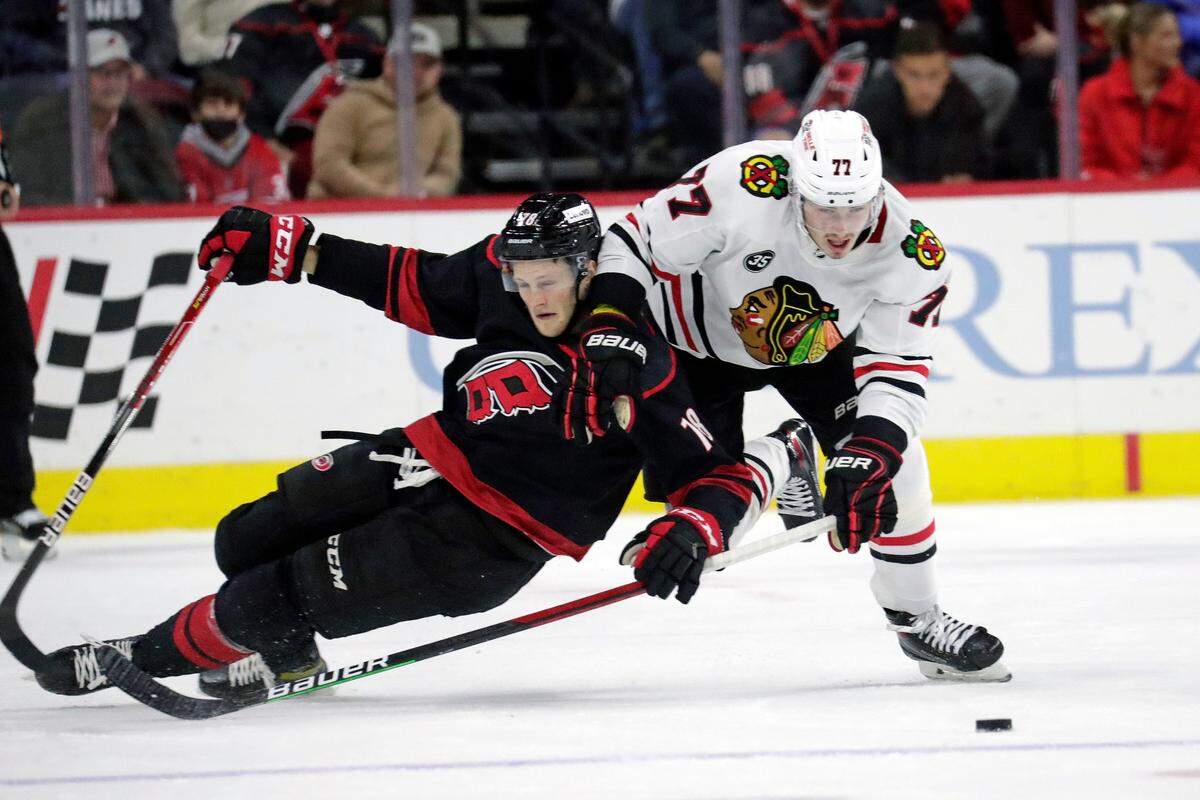 Carolina Hurricanes forward Steven Lorentz (78) battles Chicago Blackhawks center Kirby Dach (77) for the puck during NHL game Friday, Oct. 29, 2021. (AP Photo/Chris Seward)