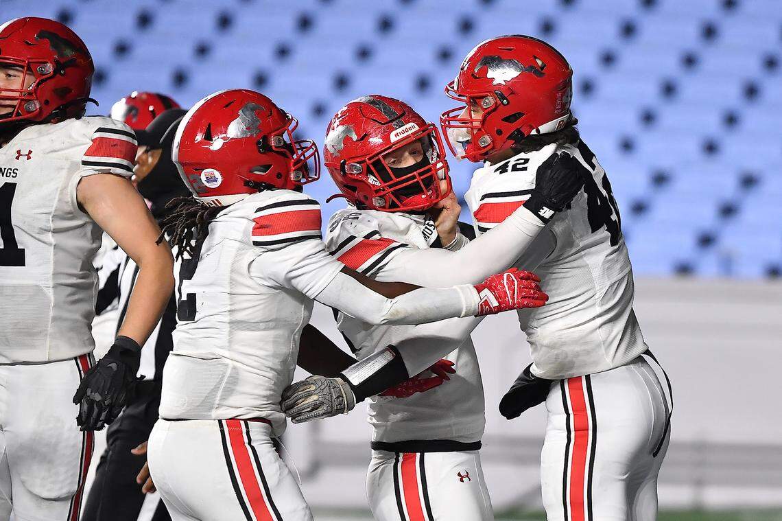 Middle Creek quarterback Ezra Jobe, left, celebrates the touchdown against Watauga with teammates during the second half in the NCHSAA 6A football cfhampionship game in Chapel Hill, North Carolina, on Dec. 12, 2025. 