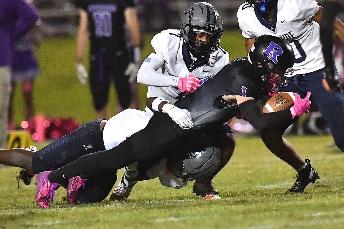 Riverside wide receiver Cole Schweitz (1) stretches for the yardage against Hillside’s Maurice Brandon (15) and Kaleb Lott (7) during the first half. The Durham Hillside Hornets and the Durham-Riverside Pirates met in a football game in Durham. N.C. on October 4, 2024.