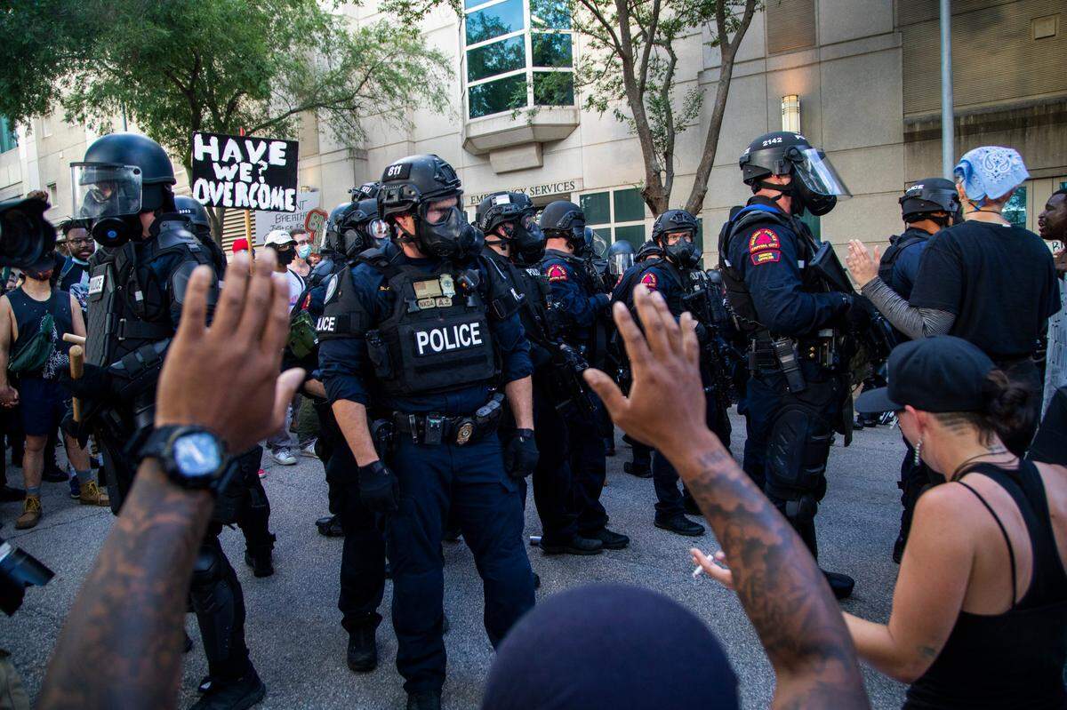 Protesters face off against police in riot gear who deployed tear, gas pepper spray and smoke bombs against protesters near the intersection of McDowell and Davie Streets in downtown Raleigh Saturday, May 30, 2020.