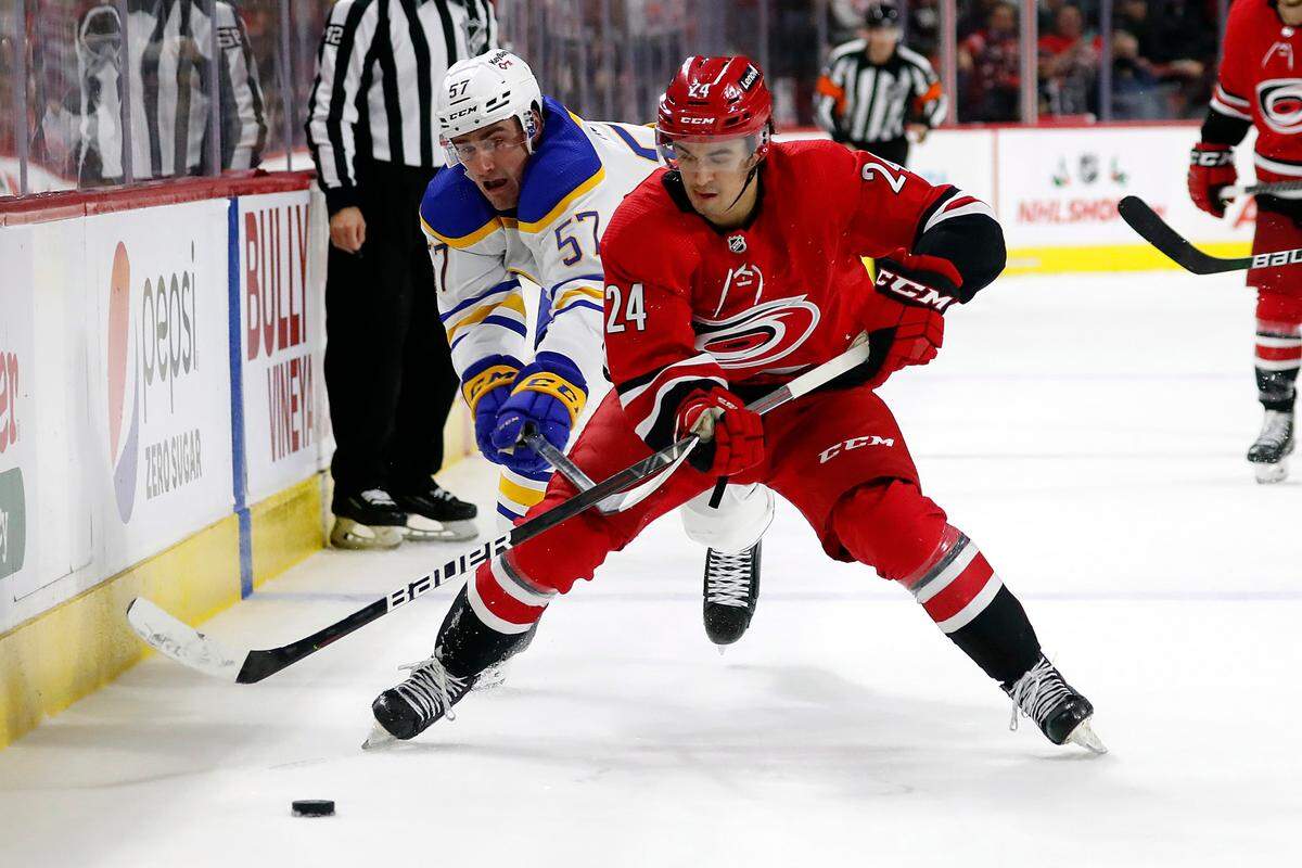 Carolina Hurricanes’ Seth Jarvis (24) controls the puck in front of Buffalo Sabres’ Brett Murray (57) during the third period of an NHL hockey game in Raleigh, N.C., Saturday, Dec. 4, 2021. (AP Photo/Karl B DeBlaker)