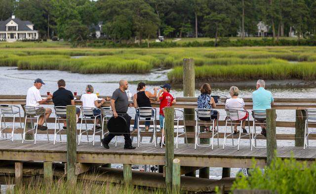 Customers of the Oyster Rock Restaurant dine along the banks of Calabash Creek on Wednesday, July 12, 2024 in Calabash, N.C.