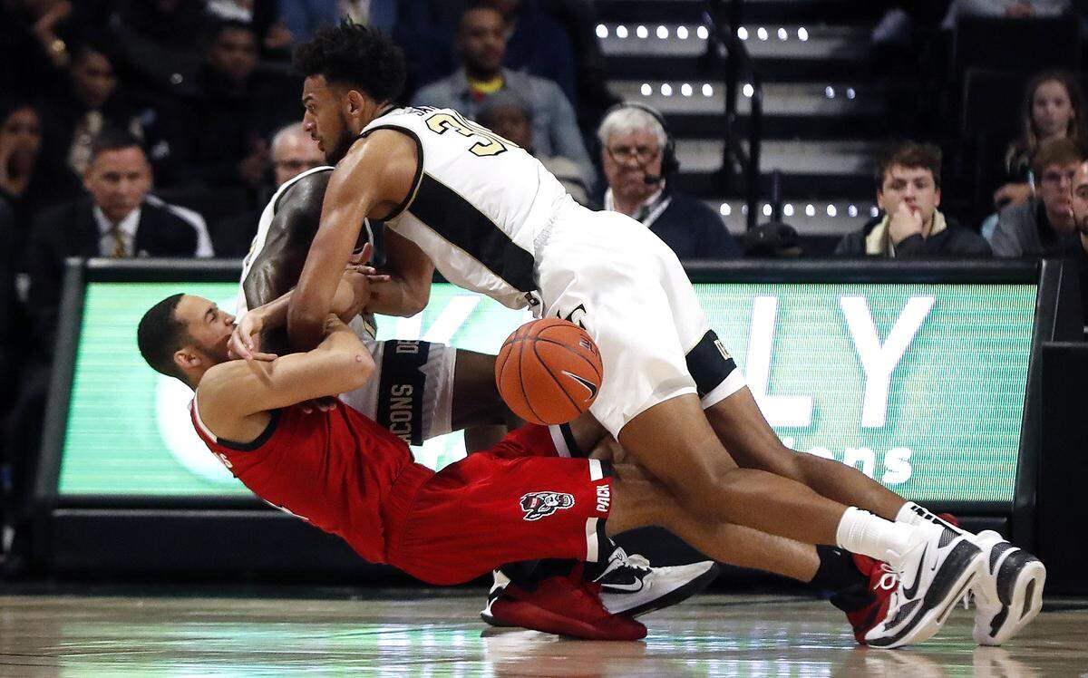 Wake Forest’s Olivier Sarr (30) falls on N.C. State’s Jericole Hellems (4), causing Hellems to be injured during the second half of N.C. State’s 91-82 victory over Wake Forest at Joel Coliseum in Winston-Salem, N.C., Saturday, Dec. 7, 2019.